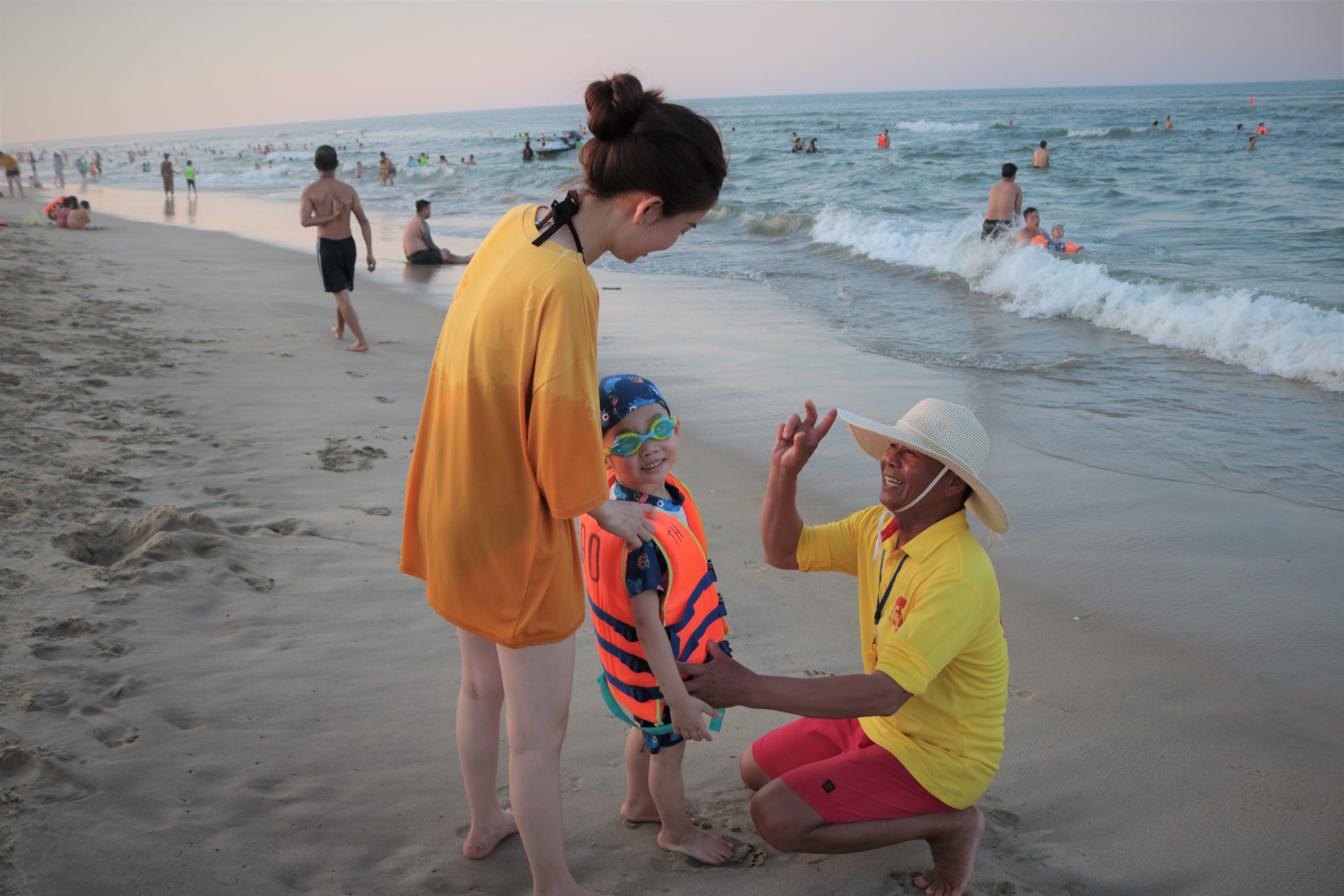 Tổ cứu hộ bãi biển Nhật Lệ hướng dẫn mang áo phao đúng cách cho trẻ.