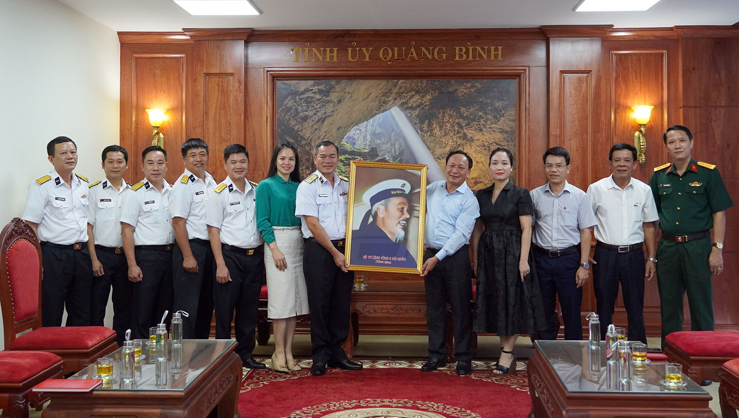 Chuẩn đô đốc Nguyễn Đăng Tiến và đồng chí Phó Bí thư Thường trực Tỉnh ủy Trần Hải Châu trao quà, chụp ảnh lưu niệm cùng các đại biểu.